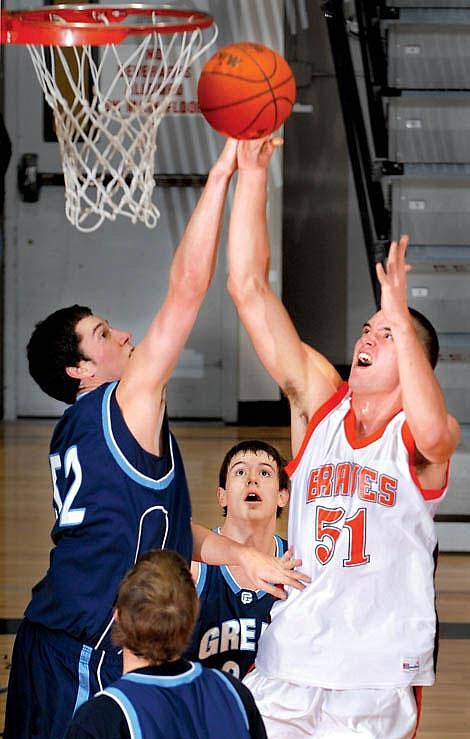 Flathead High School&#146;s Brock Osweiler (51) is fouled by Great Falls&#146; Kevin Semmens while taking the ball to the hoop Thursday night at Flathead. Garrett Cheen/Daily Inter Lake