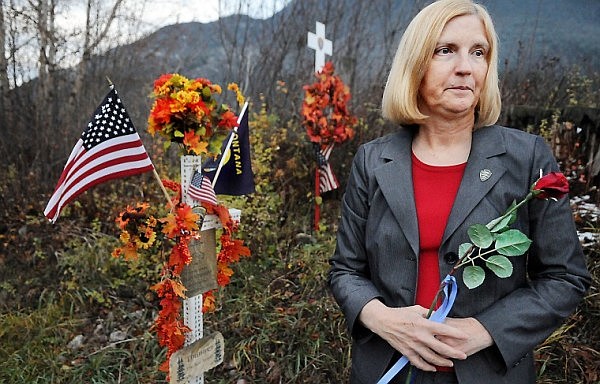 Becky Sturdevant stands near roadside crosses north of Columbia Heights on Friday evening. The crosses were erected at the site where her son, Montana Highway Patrol Trooper Evan Schneider, was killed in the line of duty by a drunk driver in August 2008.