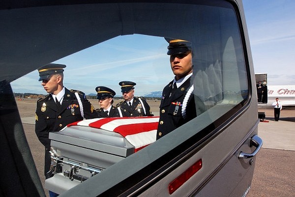 Montana National Guard Honor Guard members carry the body of Army Private First Class Nicholas Cook into a hearse Monday afternoon at Glacier Park International Airport. Cook died in Afghanistan on March 7th from wounds sustained from insurgents that attacked his unit.