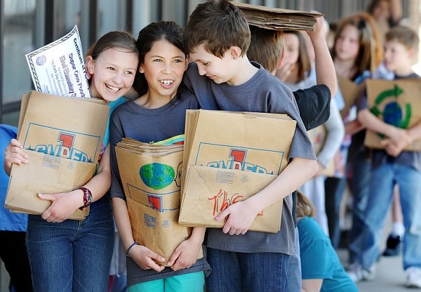 Janet Kigilyuk, left to right, Paulina Carbajal-Jepsen, and Lauryn Vornbrock, along with members of Barb Andersen's third grade class, wait anxiously outside Super 1 Foods on Tuesday in Kalispell. Students at Elrod Elementary borrowed 300 bags and decorated them with Earth Day themed art. The decorated bags will be given to customers starting at 8 a.m. on Thursday.