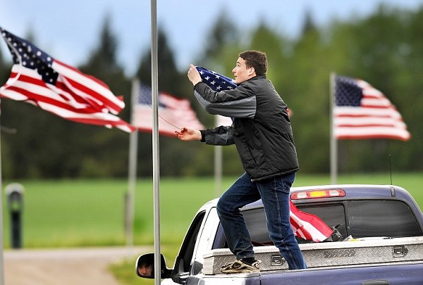 Andrew Bergstrom hangs flags along the driveway leading to Grace Baptist Church early on Sunday morning in preparation for the annual Memorial Day Service. For the past five years Grace Baptist has done a special Sunday service specifically honoring some aspect of the United States military. This year the focus was on POWs and MIAs.