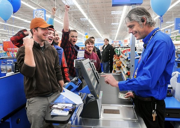 Ryan Hunt, left to right, Jason Hunt, Eddie Correa, Brian Penrod and Tyler Hunt, all cousins from the Whitefish area, celebrate as they become the first customers at Walmart with the purchase of a Hershey's chocolate bar. The group of five began their vigil outside the doors of Walmart on Tuesday night at 11 p.m. They wanted to be the first into the store so they came out with camping gear and staked their claim.