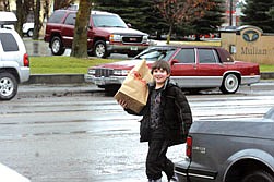 Eyrah Brown carries back a shopping bag after going to the hardware store to buy a present for the food baskets that were distributed last week.