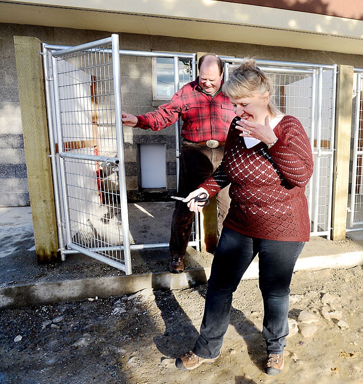 <p>Karen Burkett and Cliff Bennett, director of the Flathead County Animal Shelter, step out of one of the new kennel runs after the official ribbon cutting on Monday, December 16, in Kalispell. (Brenda Ahearn/Daily Inter Lake)</p>
