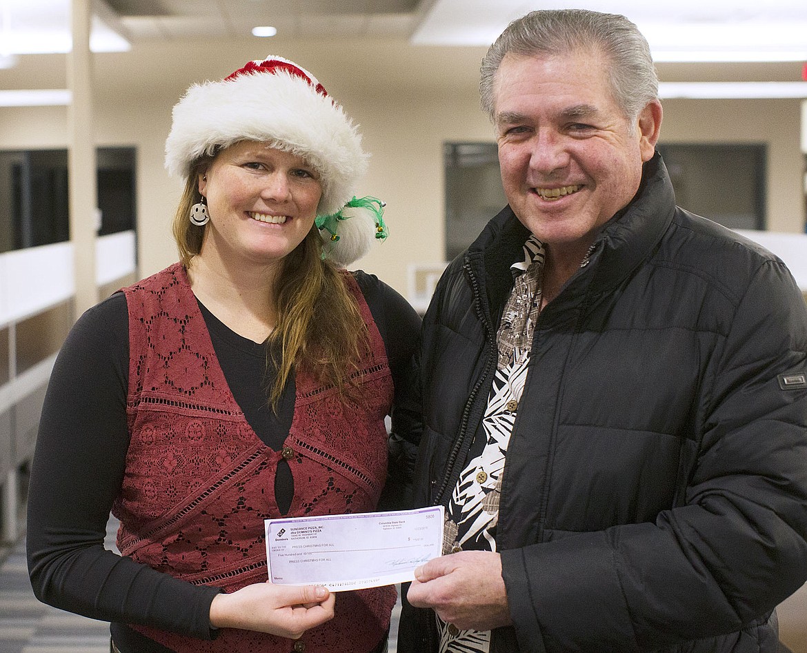 &lt;p&gt;Coeur d'Alene Press reporter Bethany Blitz accepts a $500 donation for Press Christmas For All from Jim Hightower and the employees of Domino's Pizza on Friday.&lt;/p&gt;