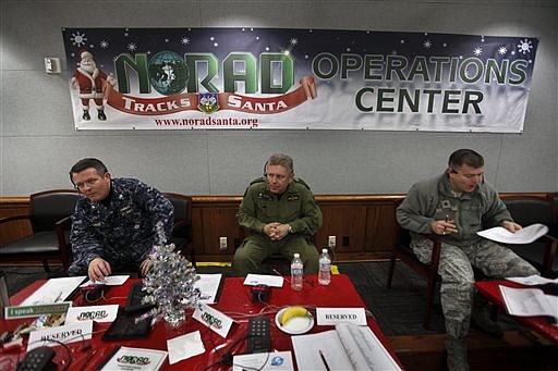 &lt;p&gt;In this Dec. 24, 2012 file photo, NORAD Deputy Commander Lt. General Alain Parent, center, of the Royal Canadian Air Force, takes phone calls from children asking where Santa is and when he will deliver presents to their house, during the annual NORAD Tracks Santa Operation, at the North American Aerospace Defense Command, or NORAD, at Peterson Air Force Base, in Colorado Springs, Colo. Also fielding calls are U.S. Navy Capt. Jeff Davis, left, and U.S. Air Force Maj. Chris Bendig. The U.S. and Canadian military will entertain millions of kids again this Christmas Eve with second-by-second updates on Santa&#146;s global whereabouts.(AP Photo/Brennan Linsley, File)&lt;/p&gt;