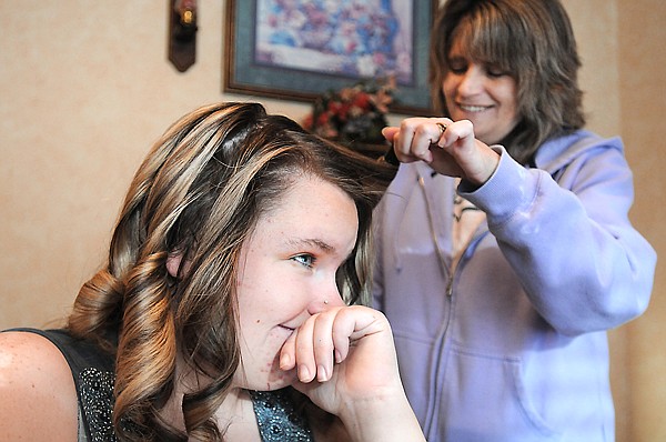 Kelsey Fey smiles as her mother Michelle curls her hair for her on Friday, December 17, at their home in Kalispell.