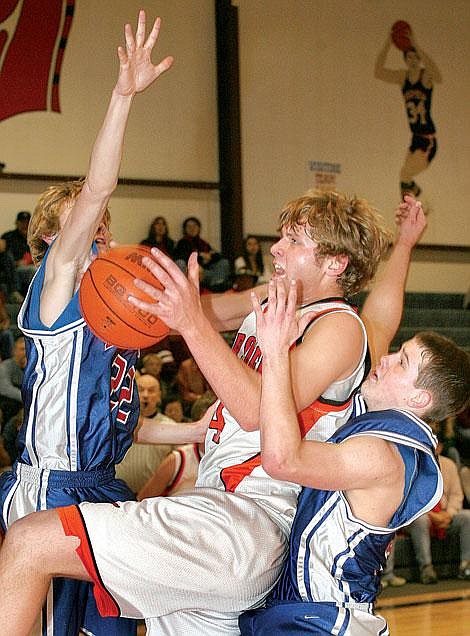 Plains Horseman Trent Thompson breaks through Superior Bobcats Tyler Stenberg (left) and Drew Walen for two points during a game at Plains.