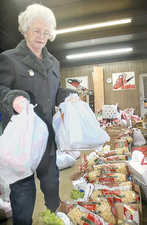 Photo by Aaric Bryan<br>Clark Fork Valley Women in Timber member Della Bell puts some presents in a food basket in Superior Friday.