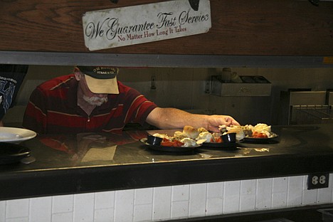&lt;p&gt;Bruce Goods serves up turkey, mashed potatoes and stuffing during the free Christmas dinner at G.W. Hunters.&lt;/p&gt;