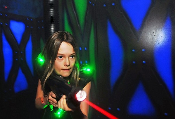 Danielle Rosenberg, 11, fires a shot from gun during a game of Laser Tag at the Zone Family Fun Center on Wednesday.