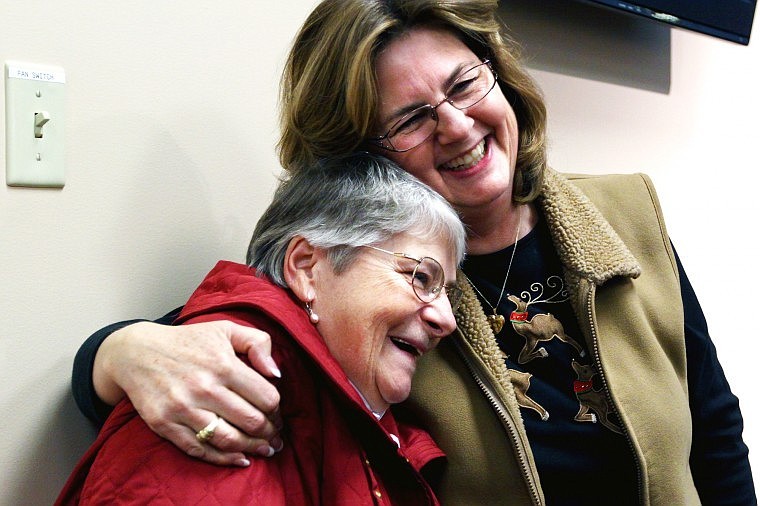 Pam Kennedy Carbonari hugs Bev Larson, wife of council member Duane Larson.