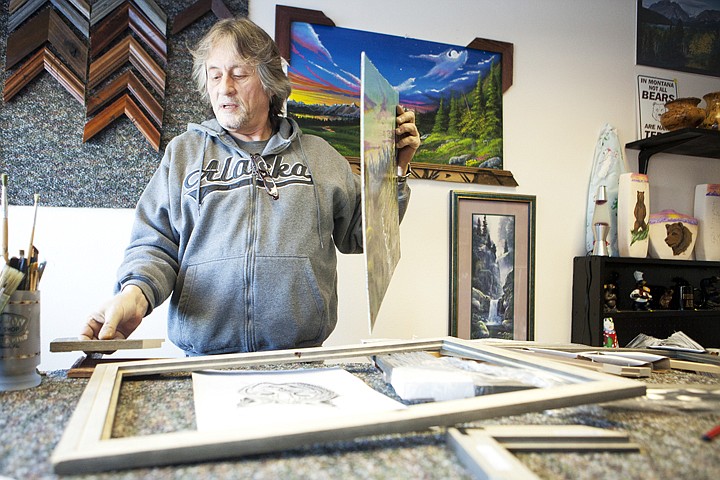 &lt;p&gt;Wayne Mosbarger frames one of his paintings at the Smoke Haus
Emporium in Evergreen Wednesday morning.&lt;/p&gt;