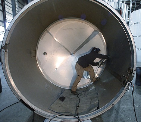 &lt;p&gt;In this Dec. 14 photo, Nathan Nettler polishes a tank at JV Northwest, in Canby, Ore. JV Northwest manufactures stainless steel vessels. The U.S. economy will grow faster in 2012 - if it isn't knocked off track by upheavals in Europe, according to an Associated Press survey of leading economists.&lt;/p&gt;