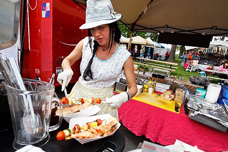 &lt;p&gt;Laura Calvert, co-owner of Jupiter Jane Traveling Cafe, prepares and order of skewered shrimp and vegetables during 2011 Post Falls Days preparation at Q'emiln Park. The event, which will now take place in July, is being renamed to Post Falls Festival.&lt;/p&gt;