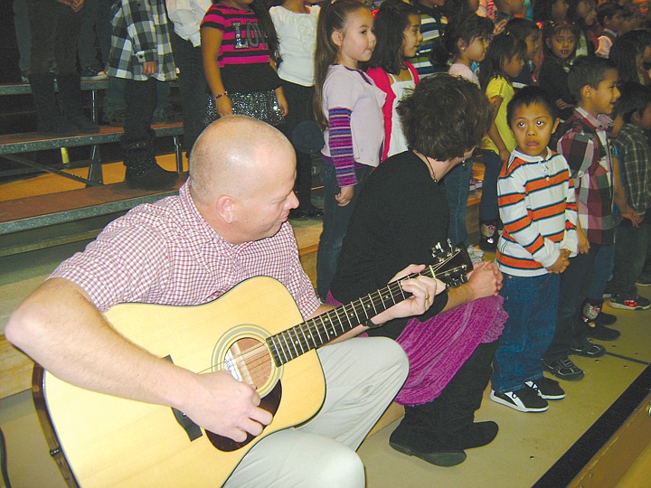 Red Rock Elementary first grade teacher Daren Christensen and
his wife Nancy Christensen, a Red Rock instructional assistant,
help kindergarten students perform "Feliz Navidad" and "The
Chipmonk Song."