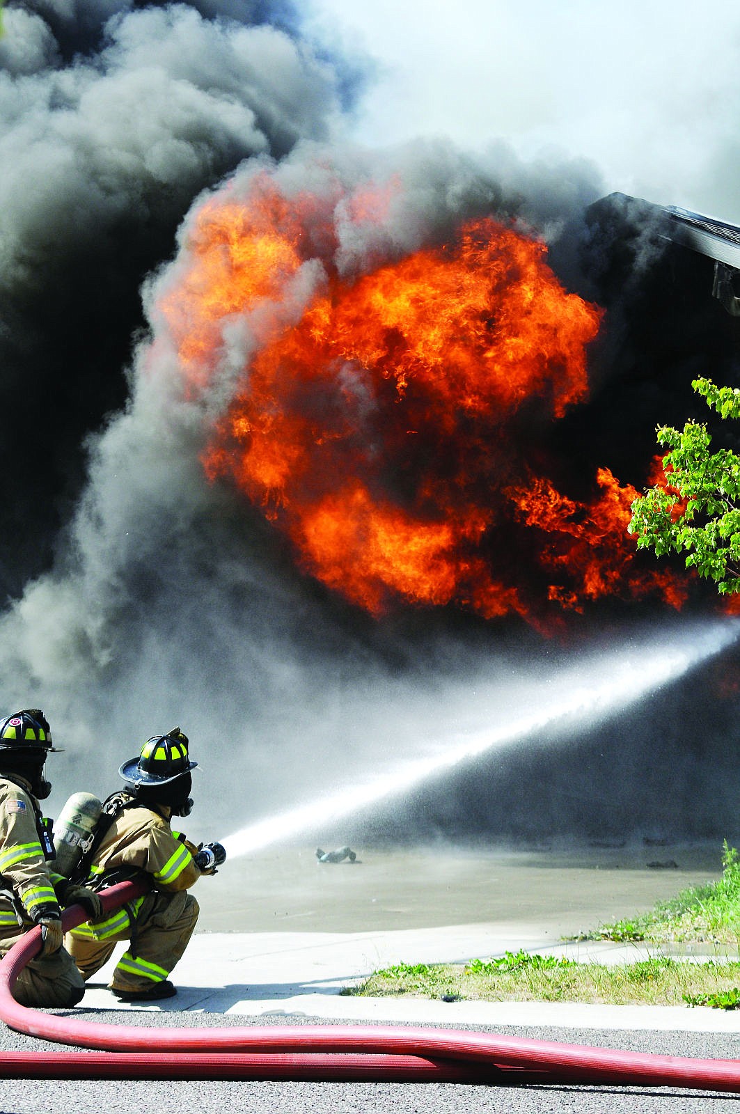 <p><strong>Firefighters</strong> work to extinguish a billowing house fire June 25 on Rockefeller Drive in Kalispell. The intensity of the fire prompted the evacuation of residents of nearby houses in the Empire Estates subdivision. One adjacent home had its siding melted. (Aaric Bryan/Daily Inter Lake)</p>