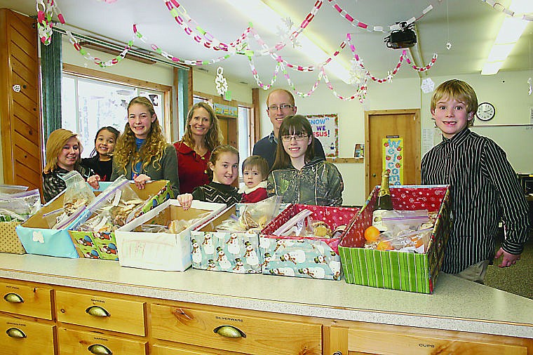 &lt;p&gt;Ashley Cardenas, Ameris Velez, Alesha Evans, Karen Evans, Mandy Velez, Alexis Carter, Brian Iseminger, Brianna Reichert and Jim Hanson stand with the nine packed holiday boxes.&lt;/p&gt;