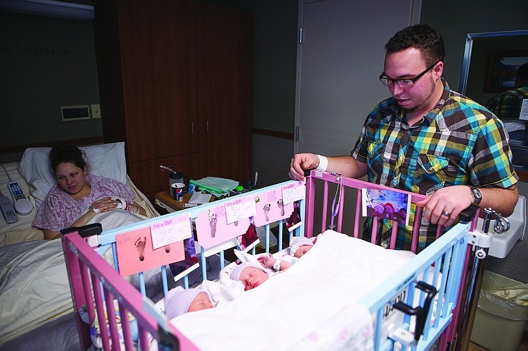 <p>Graham Cook looks over his new-born triplets Friday afternoon at Kalispell Regional Medical Center.</p>