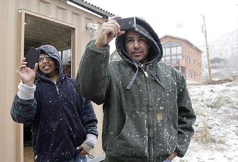 &lt;p&gt;Leonel Torres, left, and Noah Vasquez use their cell phones to take photos of the snowstorm that moved over Summerhaven, Ariz., on Wednesday.&lt;/p&gt;