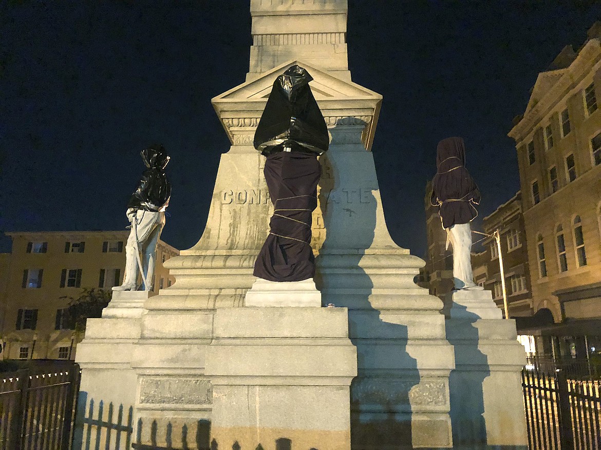 The Confederate monument is covered in sheets and bags in Downtown Portsmouth, Va., early Wednesday, June 10, 2020.   Protesters covered the monument  with trash bags and sheets Wednesday, several hours after the city's council members had a meeting to figure out ways to relocate it. (Kiahnna Patterson/WAVY-TV 10 via AP)