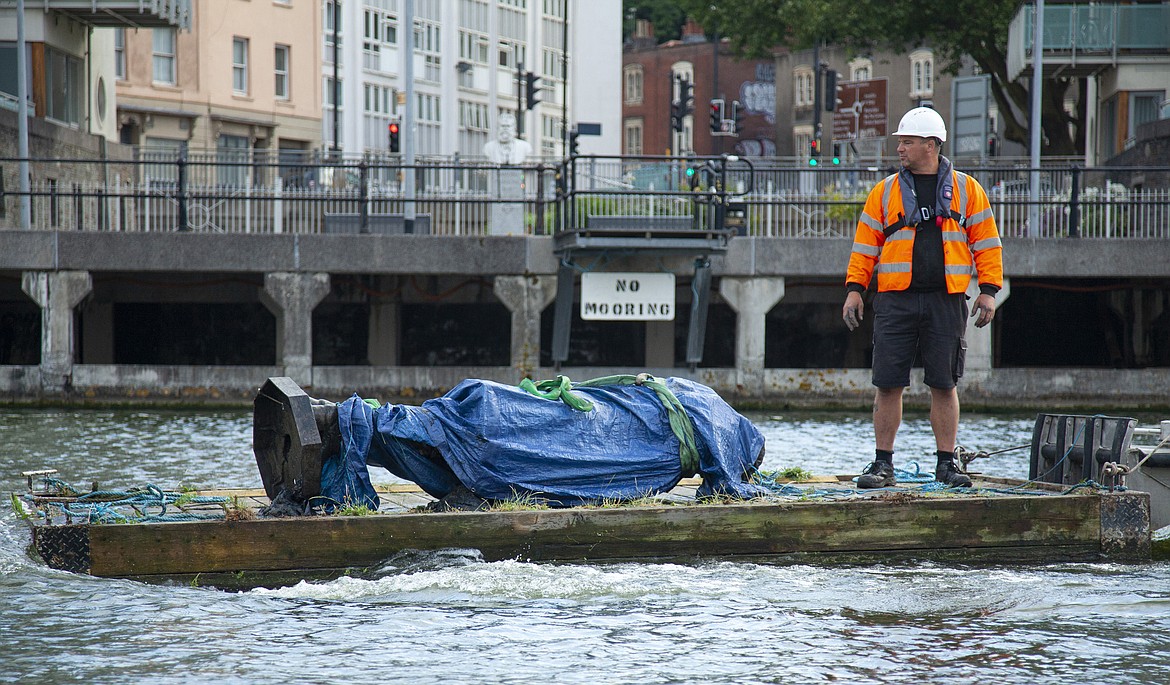 In this photograph made available by Bristol City Council, the statue of Edward Colston is recovered from the harbour in Bristol, Thursday June 11, 2020, after it was toppled by anti-racism protesters on Sunday. The council says it has been taken to a "secure location" and will end up in a museum. Colston built a fortune transporting enslaved Africans across the Atlantic, and left most of his money to charity. (Bristol City Council via AP)