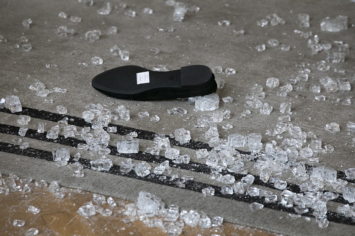 A shoe lies in the middle of shattered glass at a Madison Avenue store, Tuesday, June 2, 2020, in New York. Protesters broke into the store Monday night in reaction to George Floyd's death while in police custody on May 25 in Minneapolis. (AP Photo/Mark Lennihan)