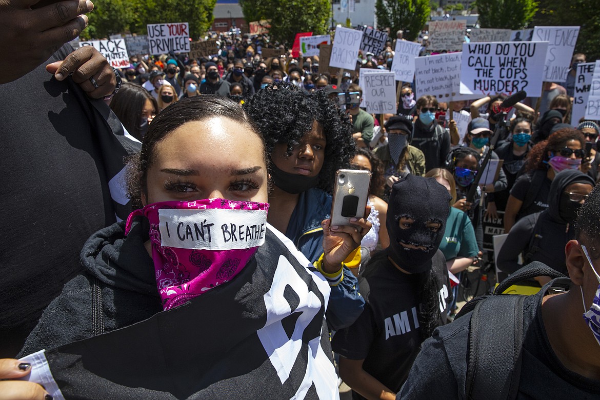 A young woman with the words "I can't breathe" on her face covering joins thousands at a Black Lives Matter event in Eugene, Ore., Sunday May 31, 2020, over the deaths of George Floyd and others (Chris Pietsch/The Register-Guard via AP)