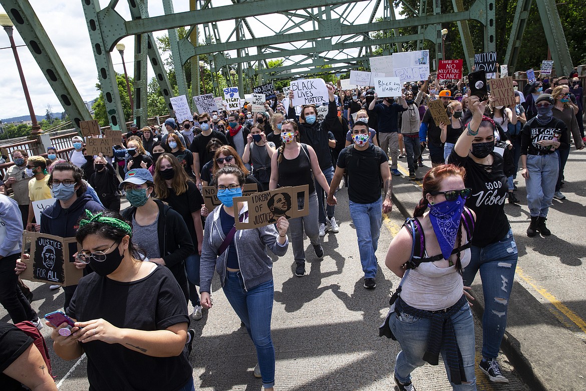 Thousands walk over the Ferry Street Bridge in Eugene, Ore., during a Black Lives Matter March on Sunday, May 31, 2020, about the deaths of George Floyd and others. (Chris Pietsch/The Register-Guard via AP)