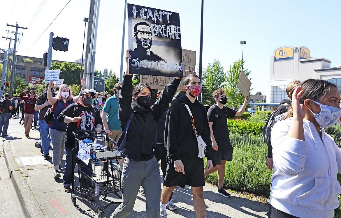 People peacefully protest at University Village, Monday, June 1, 2020, in Seattle as demonstrations continued, sparked by the death of George Floyd in Minneapolis. (Ken Lambert/The Seattle Times via AP)