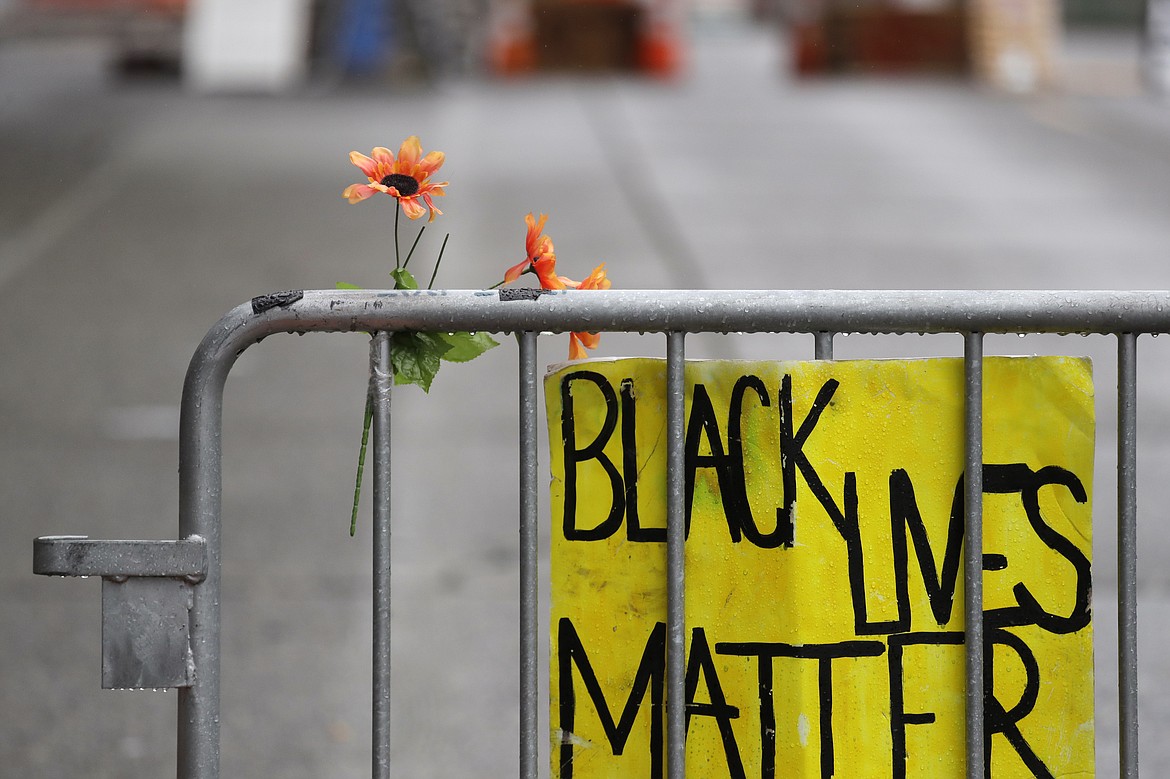 A barricade stands at the end of a street where a plywood-covered and closed Seattle police precinct stands Tuesday, June 9, 2020, in Seattle, following protests over the death of George Floyd, a black man who was in police custody in Minneapolis. Under pressure from city councilors, protesters and dozens of other elected leaders who have demanded that officers dial back their tactics, the police department on Monday removed barricades near its East Precinct building in the Capitol Hill neighborhood, where protesters and riot squads had faced off nightly. Protesters were allowed to march and demonstrate in front of the building, and the night remained peaceful. (AP Photo/Elaine Thompson)