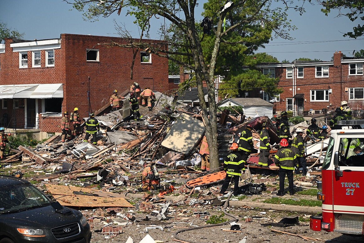 Firefighters at the scene of where homes are destroyed  Monday, August 10, 2020 at Boxhill Road and Reisterstown Road in Northeast Baltimore. A natural gas explosion has completely destroyed three row houses in Baltimore, killing at least one person and critically injuring several others.  (Jerry Jackson/The Baltimore Sun via AP)