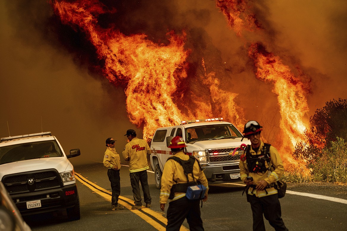 Flames from the LNU Lightning Complex fires leap above Butts Canyon Road on Sunday, Aug. 23, 2020, in unincorporated Lake County, Calif.  (AP Photo/Noah Berger)