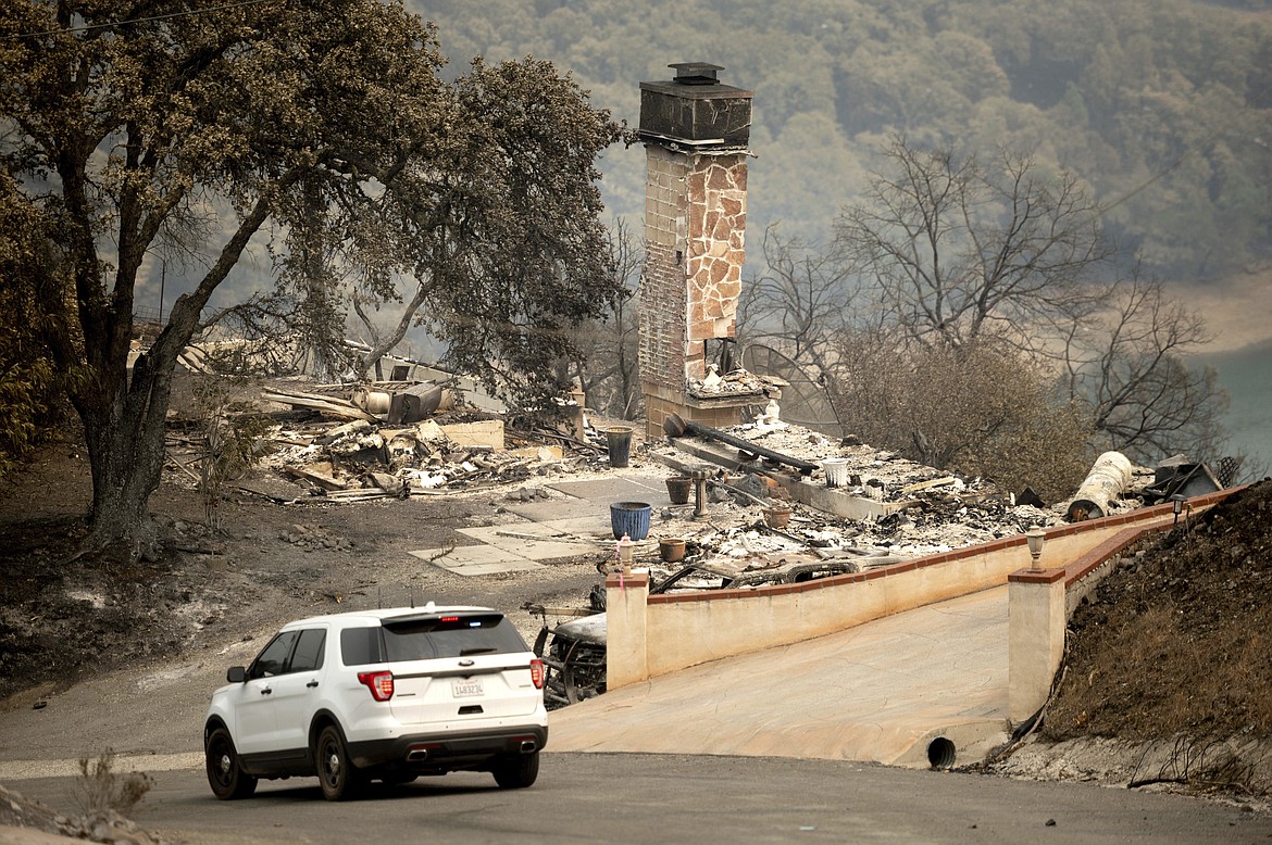 Following the LNU Lightning Complex fires, a sheriff's deputy patrols the evacuated community of Spanish Flat in Napa County, Calif. on Monday, Aug. 24, 2020. (AP Photo/Noah Berger)