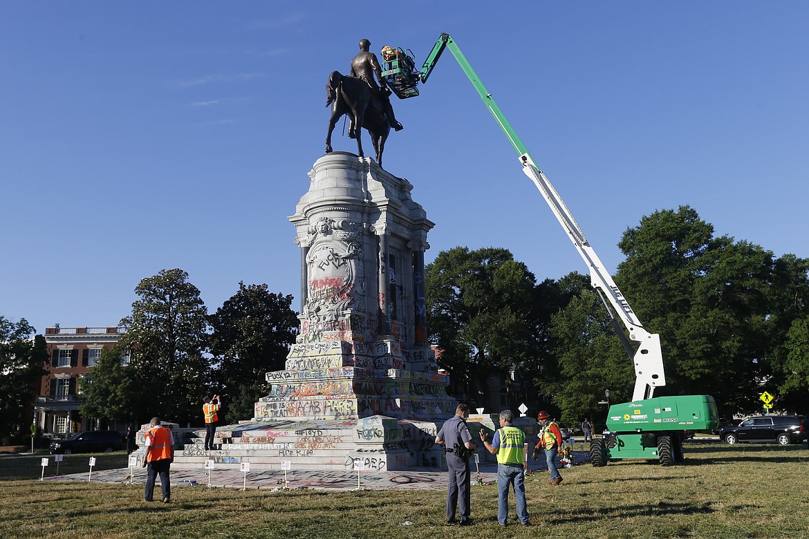 EDS NOTE: OBSCENITY - An inspection crew from the Virginia Department of General Services inspect the statue of Confederate Gen. Robert E. Lee on Monument Avenue Monday June. 8, 2020, in Richmond, Va. Virginia Gov. Ralph Northam has ordered the removal of the statue. (AP Photo/Steve Helber)