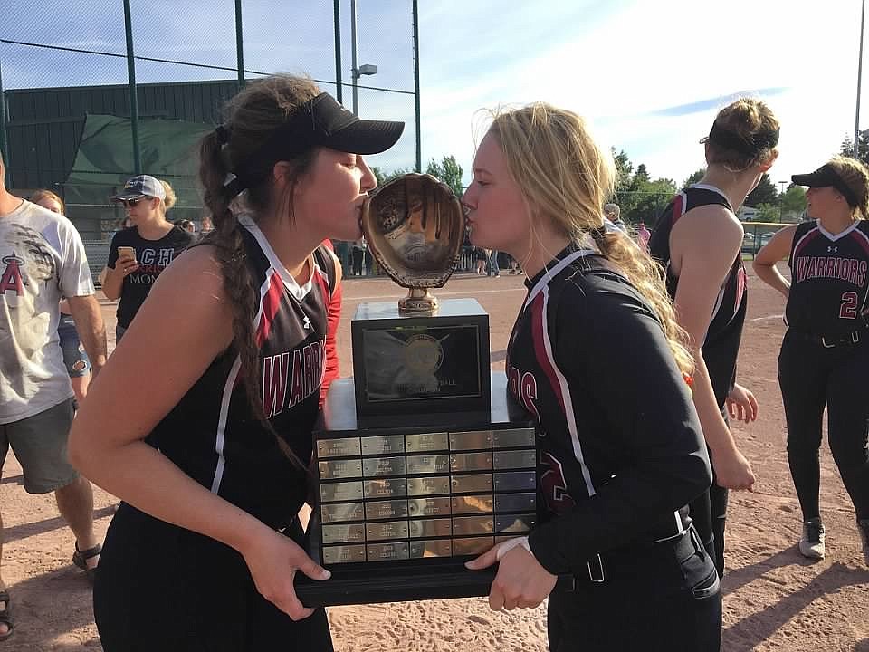 Mikayla Rushton, left, and Kendel Correia, right, kiss their new trophy after the 1B state championship game.