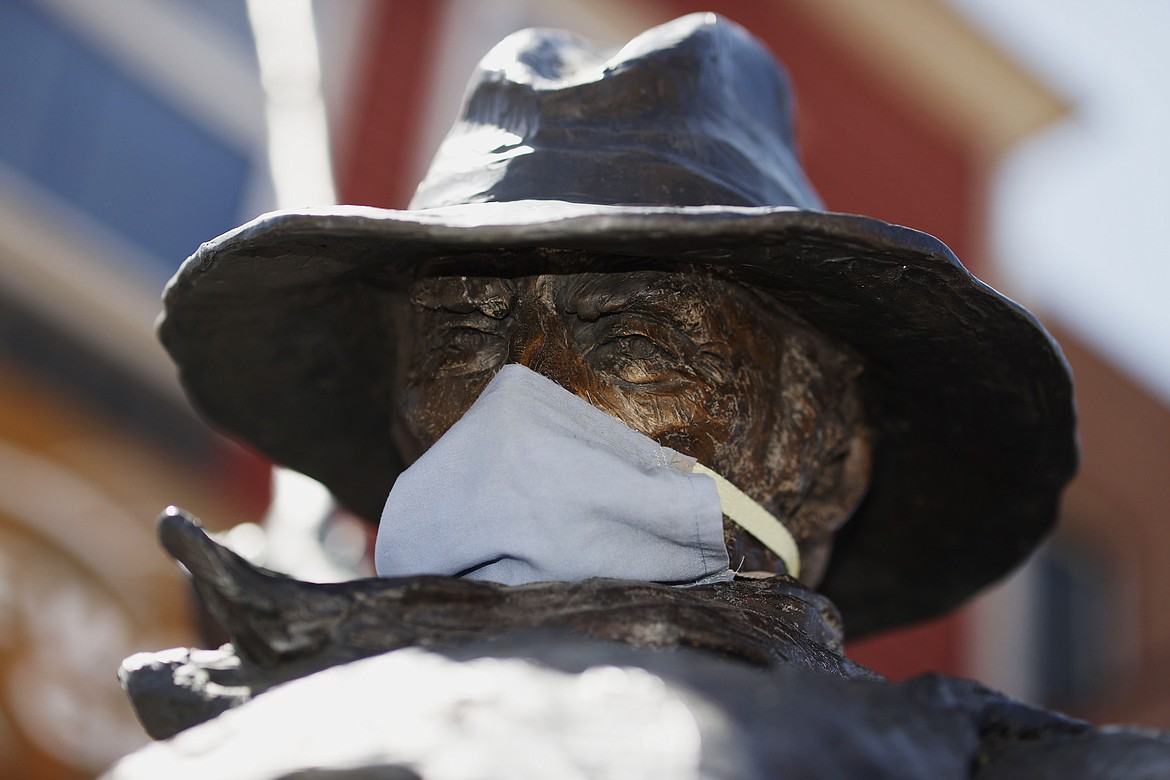 A face mask covers the nose and mouth of a sculpture entitled "Cowboy's Day Off" along Washington Avenue Thursday, May 7, 2020, in Golden, Colo. The U.S. government is poised to report the worst set of job numbers since record-keeping began in 1948, a stunning snapshot of the toll the coronavirus has taken on a now-shattered economy. (AP Photo/David Zalubowski)
