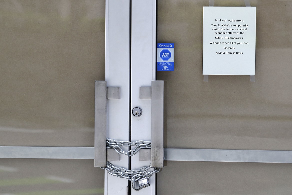 In this May 6, 2020 photo, a chain lock is shown on the entry doors to Zane + Wylie's Seattle Steakhouse restaurant in downtown Seattle. The U.S. government is poised to report the worst set of job numbers since record-keeping began in 1948, a stunning snapshot of the toll the coronavirus has taken on a now-shattered economy. (AP Photo/Ted S. Warren)