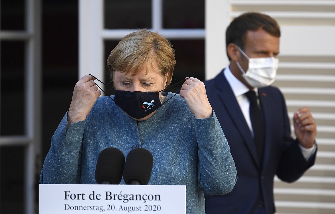 German Chancellor Angela Merkel, left, and French President Emmanuel Macron arrives for a press conference at the Fort de Bregancon, southern France, Thursday, Aug. 20, 2020. The leaders of Germany and France are meeting Thursday at a Mediterranean retreat for talks on how to resuscitate Europe's economy without causing a new virus crisis, and on a growing number of global hot spots. (Christophe Simon/Pool Photo via AP)