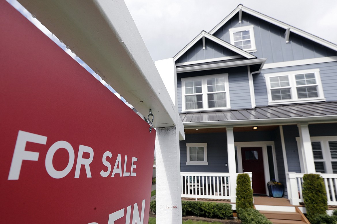 FILE - In this April 1, 2020 photo, a "For Sale" sign stands in front of a home that is in the process of being sold in Monroe, Wash., outside of Seattle. U.S. home sales rose a record-breaking 24.7% in July, extending last month’s rebound after the coronavirus pandemic all but froze the housing market this spring, the National Association of Realtors said Friday, Aug. 21, 2020. (AP Photo/Elaine Thompson, File)