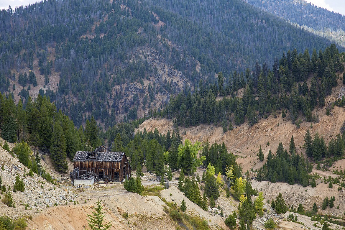 FILE - This Sept. 19, 2018, file photo, shows the last standing building above the Yellow Pine Pit open-pit gold mine in the Stibnite Mining District in central Idaho. A Canadian company that is seeking U.S. approval for three open-pit gold mines in central Idaho is suing the U.S. government contending U.S. officials are allowing water pollution at the heavily-mined site in violation of environmental laws. British Columbia-based Midas Gold filed the lawsuit Tuesday, Aug. 18, 2020, against the U.S. Forest Service under the citizen enforcement provision of the Clean Water Act. (Riley Bunch/The Idaho Press-Tribune via AP, File)