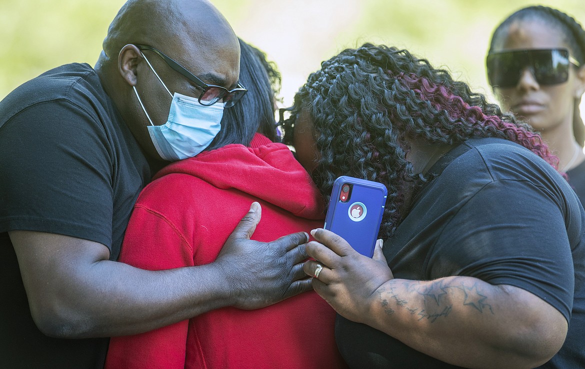 Family members hug during a press conference to announce federal charges on behalf of the family of Dreasjon Reed, Tuesday, June 16, 2020 in Indianapolis. Reed was fatally shot by an Indianapolis police officer. (Robert Scheer/The Indianapolis Star via AP)