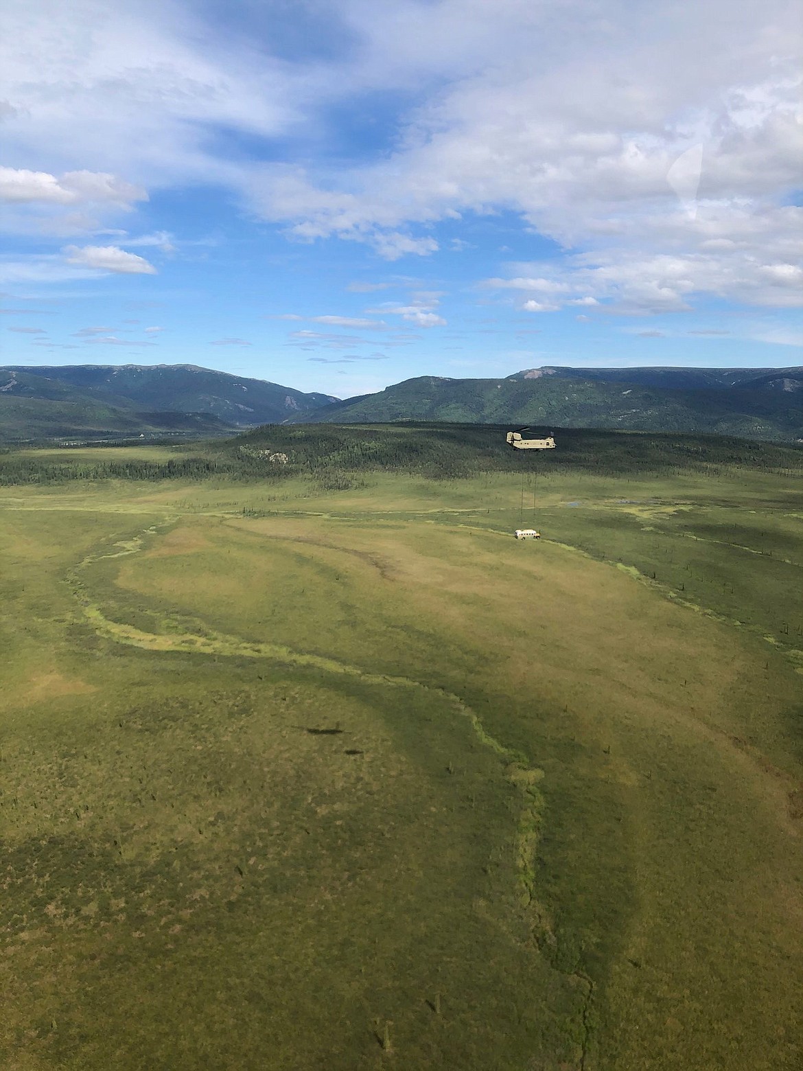 In this photo released by the Alaska National Guard, Alaska Army National Guard soldiers use a CH-47 Chinook helicopter to airlift an abandoned bus, popularized by the book and movie "Into the Wild," out of its location in the Alaska backcountry in light of public safety concerns, as part of a training mission Thursday, June 18, 2020. Alaska Natural Resources Commissioner Corri Feige, in a release, said the bus will be kept in a secure location while her department weighs various options for what to do with it. (Sgt. Seth LaCount/Alaska National Guard via AP)