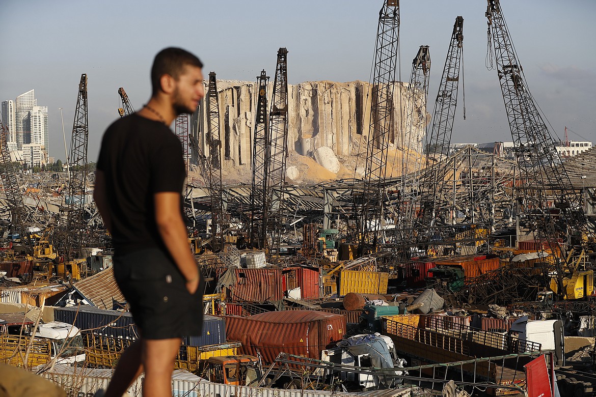A man looks at the scene of Tuesday's explosion that hit the seaport of Beirut, Lebanon, Friday, Aug. 7, 2020. Rescue teams were still searching the rubble of Beirut's port for bodies on Friday, nearly three days after a massive explosion sent a wave of destruction through Lebanon's capital.  (AP Photo/Hussein Malla)