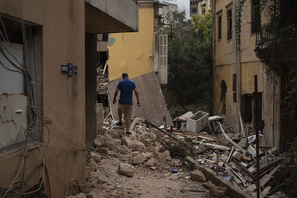 A man walks over debris of a damaged house, at a neighborhood near the scene of Tuesday's explosion that hit the seaport of Beirut, Lebanon, Friday, Aug. 7, 2020. Rescue teams were still searching the rubble of Beirut's port for bodies on Friday, nearly three days after a massive explosion sent a wave of destruction through Lebanon's capital. (AP Photo/Felipe Dana)