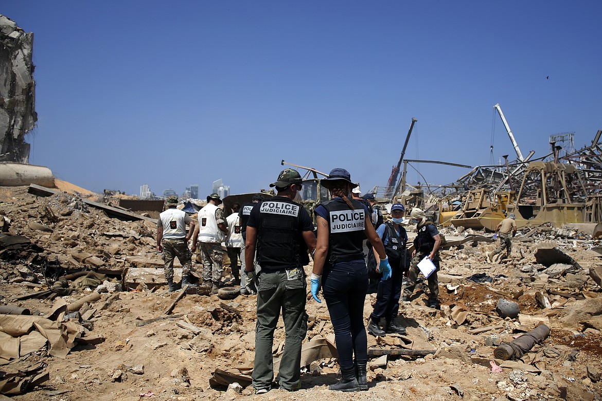 FILE - In this Aug. 8, 2020 file photo, French criminal police officers work on the site of this week's massive explosion in the port of Beirut, Lebanon For many Lebanese, their greatest hope for credible answers about the blast that wrecked much of their capital lies with outsiders.  (AP Photo/Thibault Camus, File)