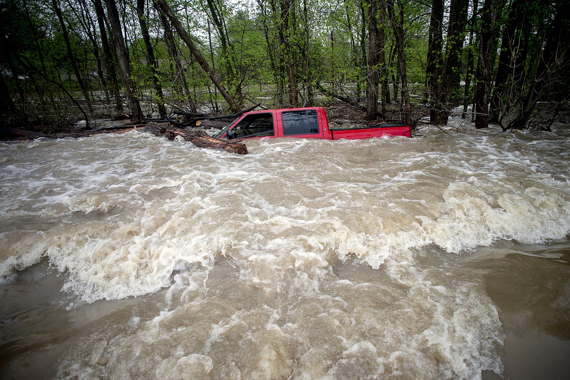 Tittabawassee Fire and Rescue rescued the driver from this red pickup truck on Norh Gleaner Road near its intersection with Tittabawassee Road on Tuesday, May 19, 2020 in Saginaw County, Mich. The truck was swept off of the road by standing water. (Jake May/The Flint Journal via AP)/
