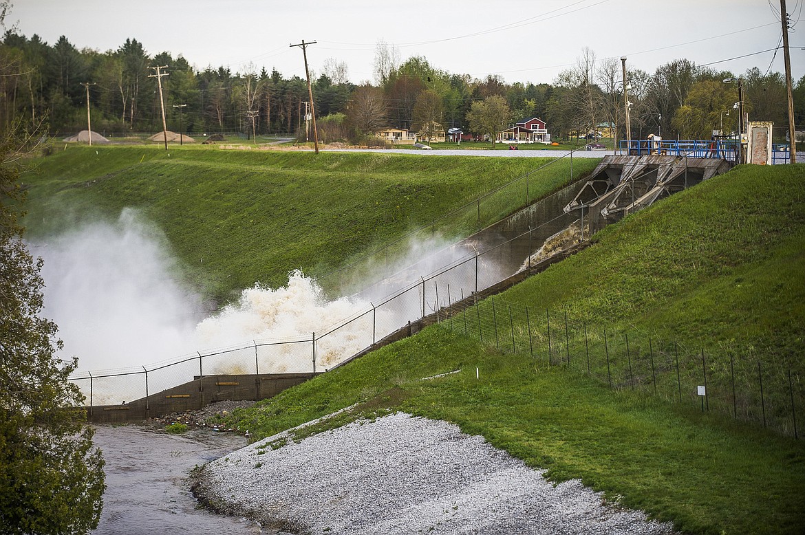 Water rushes through the Edenville Dam, Tuesday, May 19, 2020 in Edenville, Mich. People living along two mid-Michigan lakes and parts of a river have been evacuated following several days of heavy rain that produced flooding and put pressure on dams in the area. (Katy Kildee/Midland Daily News via AP)