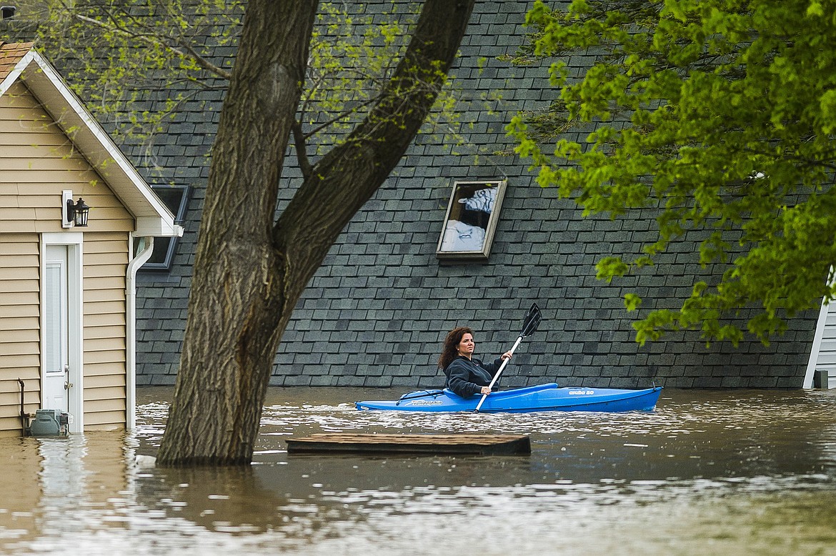 People use kayaks to assess the damage at homes in their neighborhood on Oakridge Road on Wixom Lake, Tuesday, May 19, 2020 in Beaverton, Mich. (Katy Kildee/Midland Daily News via AP)