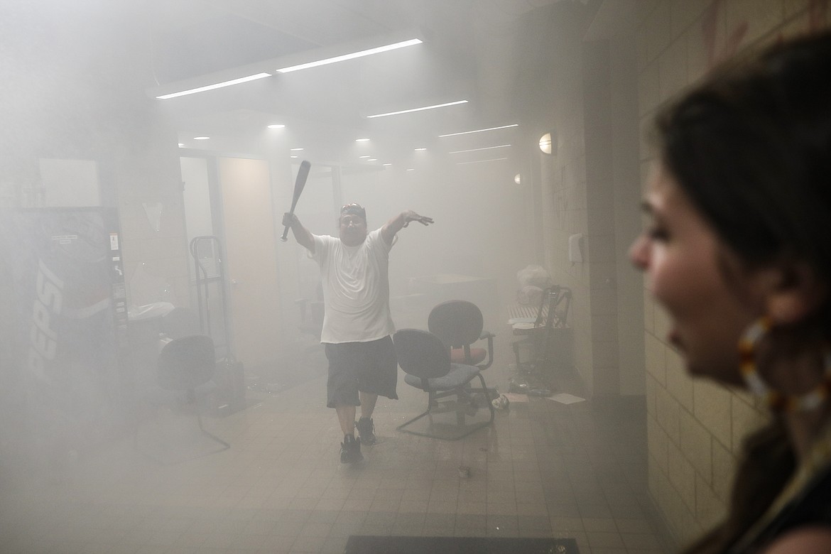 Protestors enter a burning Minneapolis 3rd Police Precinct, Thursday, May 28, 2020, in Minneapolis. Protests over the death of George Floyd, a black man who died in police custody Monday, broke out in Minneapolis for a third straight night. (AP Photo/John Minchillo)